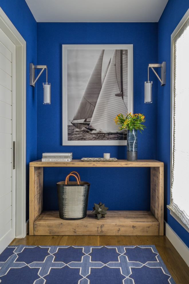 Idee per un ingresso o corridoio stile marinaro con pareti blu, pavimento in legno massello medio e pavimento marrone
