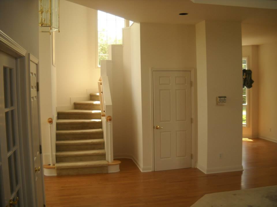 Inspiration pour un grand couloir traditionnel avec un mur blanc, un sol en bois brun et un sol marron.