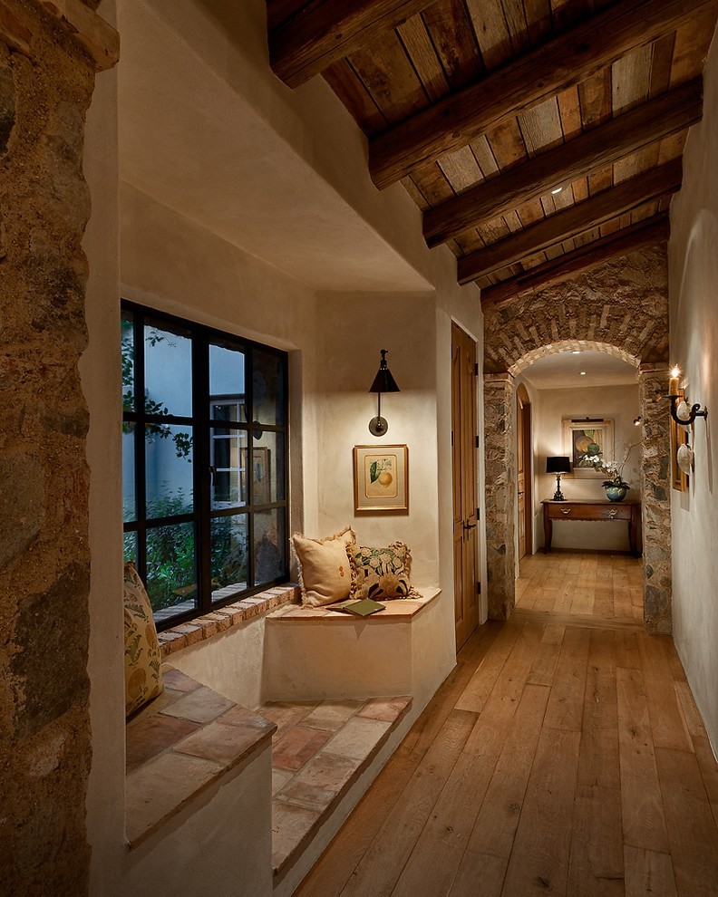 Modelo de recibidores y pasillos rurales con paredes beige, suelo de madera en tonos medios y suelo marrón