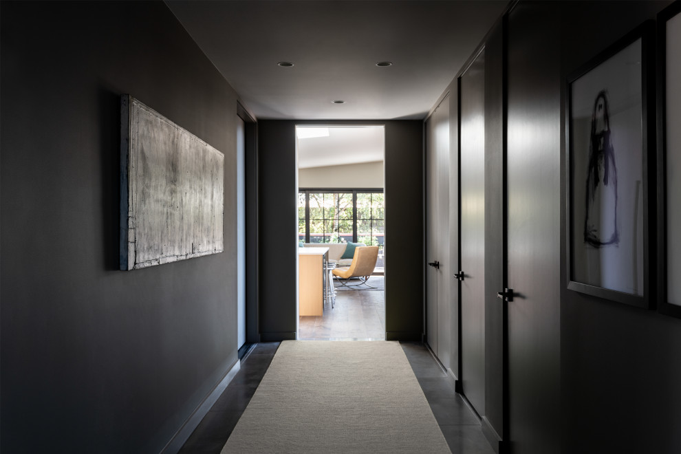 Cette image montre un couloir design de taille moyenne avec un mur gris, un sol en carrelage de céramique et un sol gris.