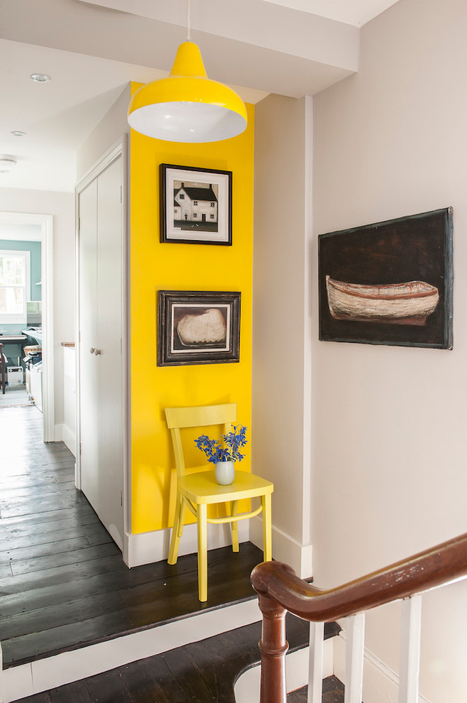 Foto de recibidores y pasillos bohemios de tamaño medio con paredes amarillas y suelo de madera oscura