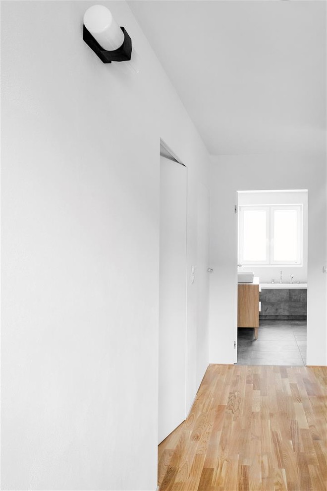 Idee per un ingresso o corridoio minimalista di medie dimensioni con pareti bianche e parquet chiaro