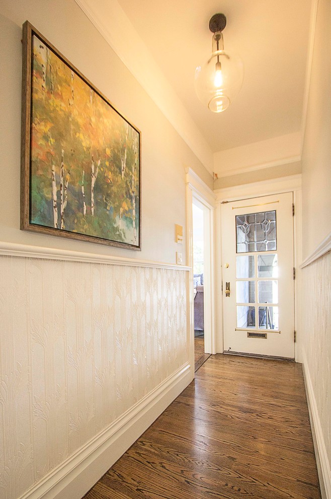 Foto de recibidores y pasillos clásicos renovados de tamaño medio con paredes blancas y suelo de madera en tonos medios
