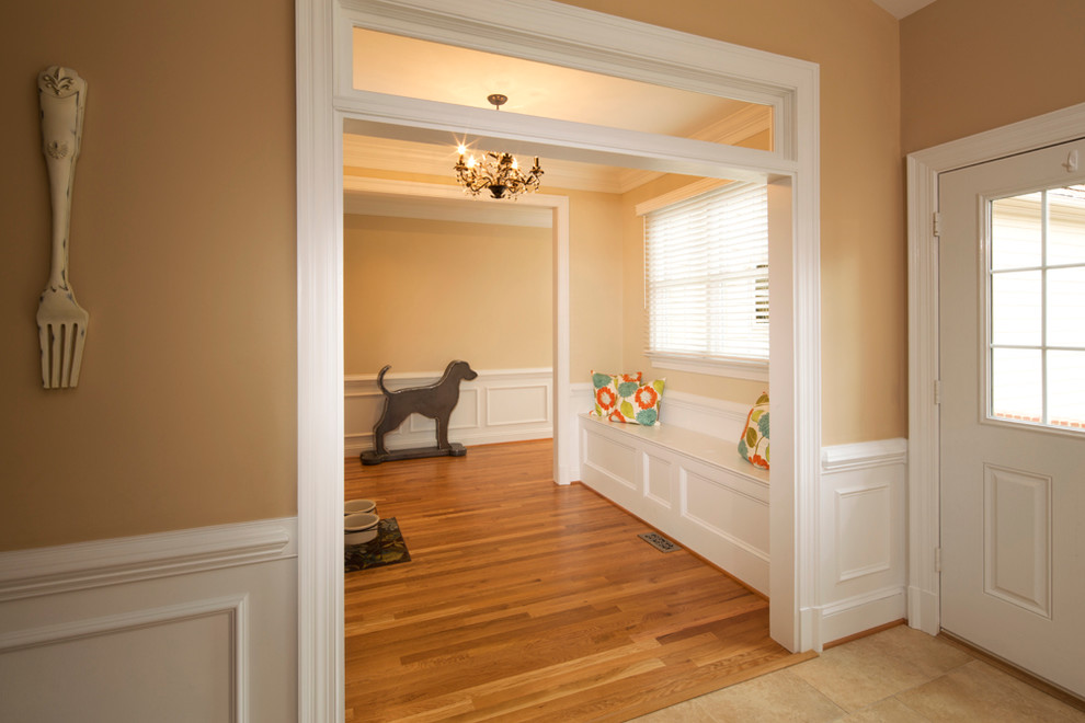 Cette photo montre un couloir chic de taille moyenne avec un sol en bois brun et un mur beige.