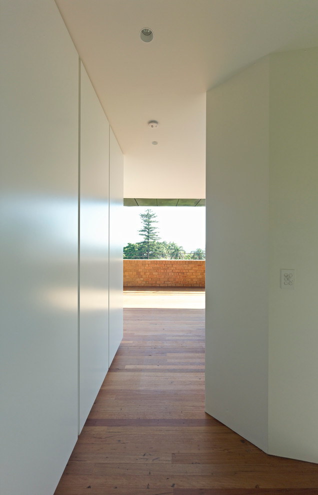 Großer Moderner Flur mit weißer Wandfarbe und braunem Holzboden in Sydney