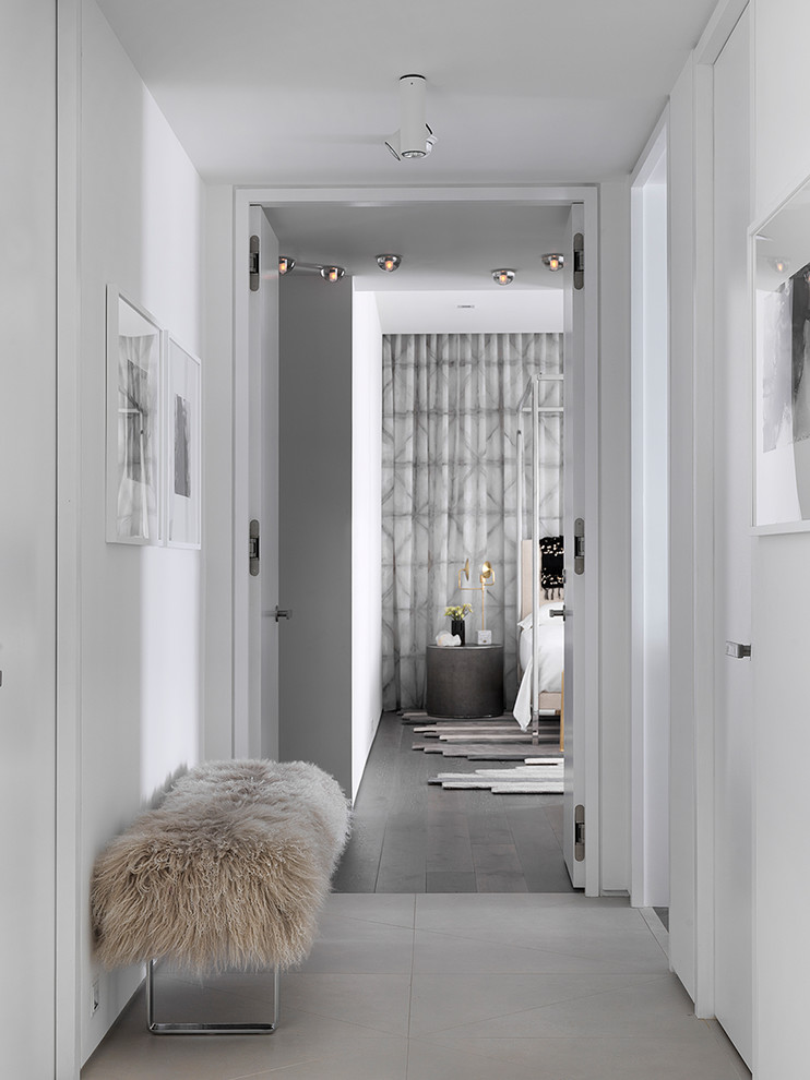 Cette photo montre un couloir tendance avec un mur blanc et un sol gris.