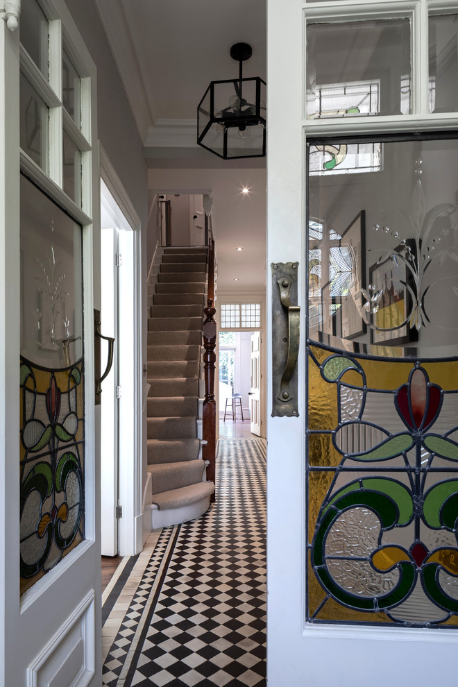 Diseño de recibidores y pasillos clásicos de tamaño medio con paredes beige, suelo de baldosas de porcelana y suelo multicolor