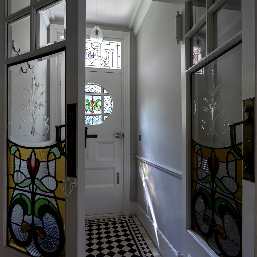 Imagen de recibidores y pasillos tradicionales de tamaño medio con paredes beige, suelo de baldosas de porcelana y suelo multicolor