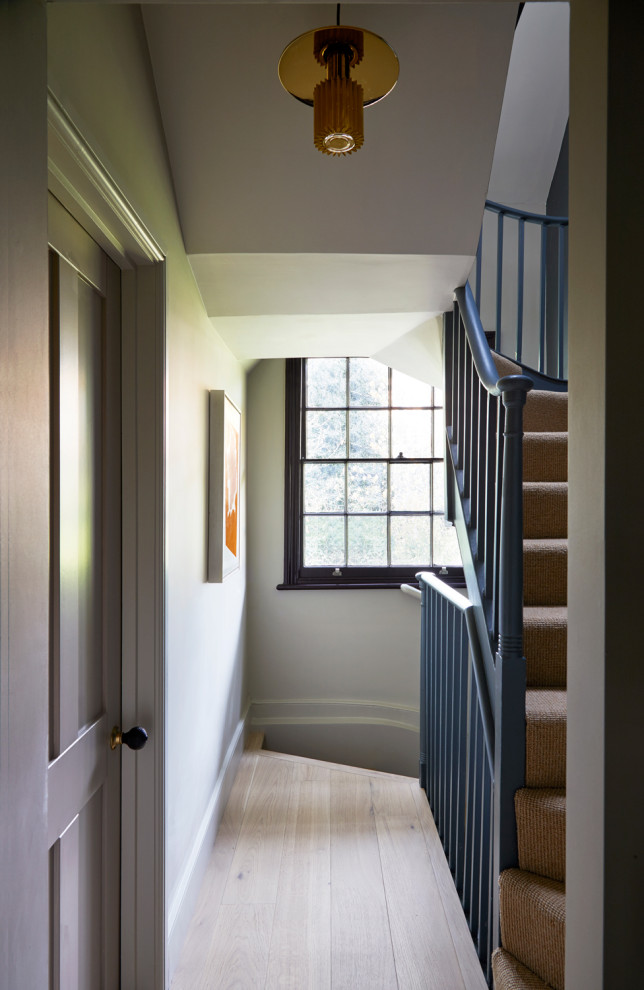 Idées déco pour un couloir classique de taille moyenne avec un mur beige, un sol en bois brun et un sol beige.