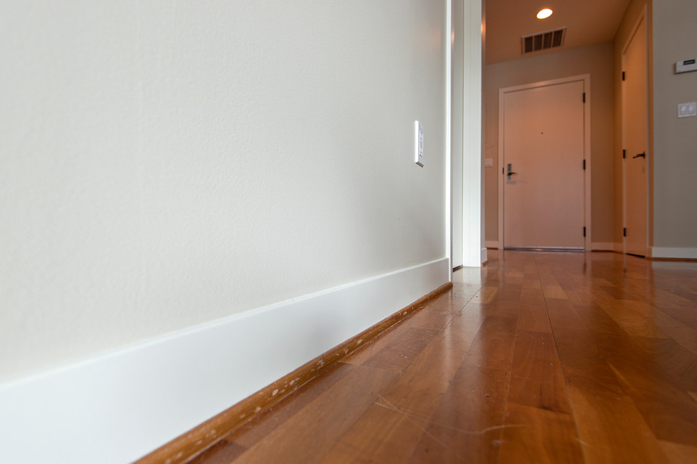 Esempio di un ingresso o corridoio di medie dimensioni con pareti beige e pavimento in legno massello medio