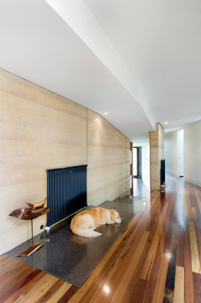 Großer Moderner Flur mit gelber Wandfarbe und dunklem Holzboden in Melbourne