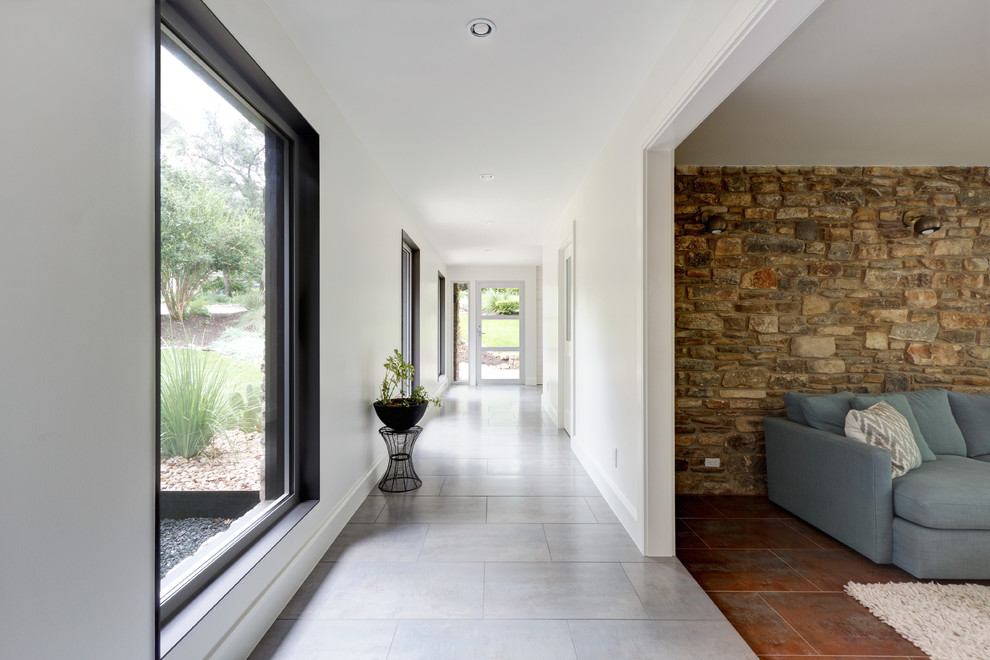 Example of a transitional porcelain tile hallway design in Austin with white walls