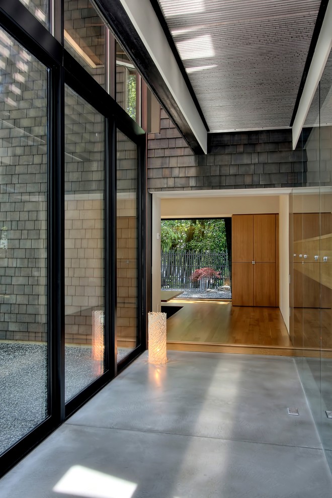 Inspiration pour un couloir design avec sol en béton ciré et un sol gris.