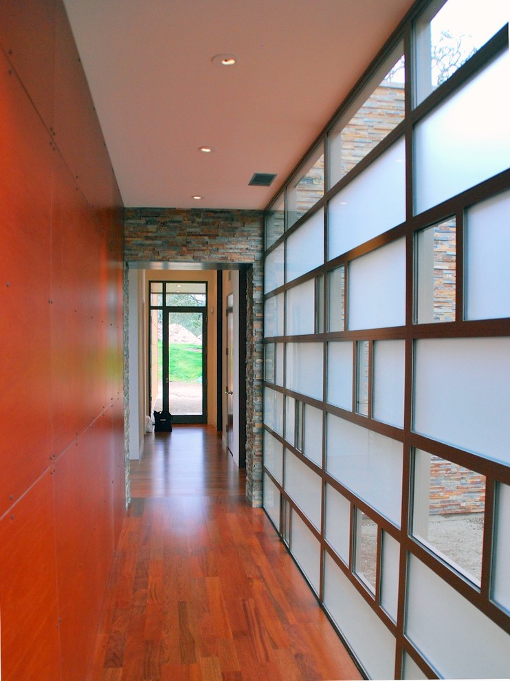 Cette photo montre un grand couloir asiatique avec un mur marron et parquet foncé.