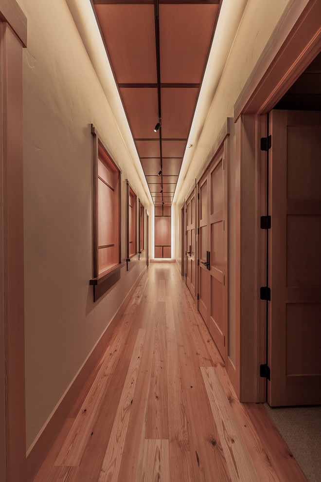 Modelo de recibidores y pasillos modernos grandes con paredes beige y suelo de madera en tonos medios