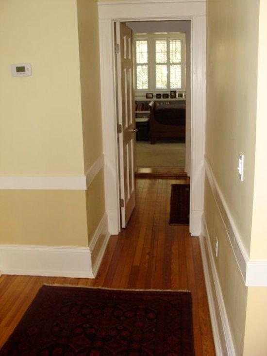 Aménagement d'un couloir classique de taille moyenne avec un mur jaune et un sol en bois brun.