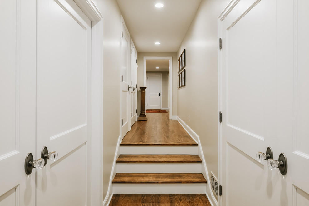 Стильный дизайн: большой коридор в классическом стиле с белыми стенами и светлым паркетным полом - последний тренд