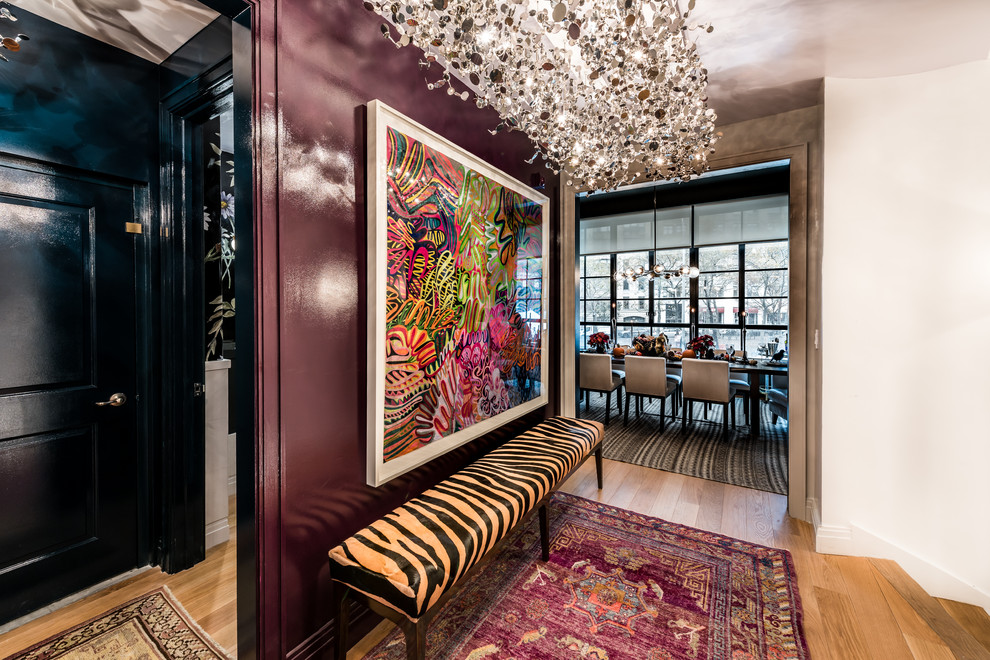 Hallway - large eclectic medium tone wood floor hallway idea in New York with purple walls