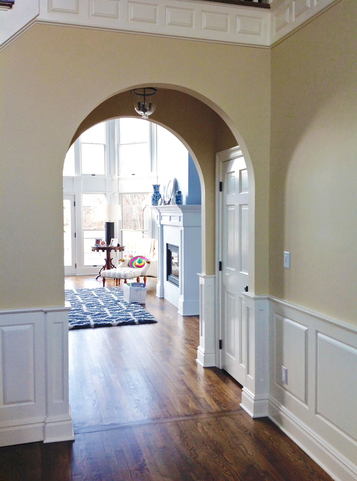 Esempio di un grande ingresso o corridoio chic con pareti beige e pavimento in legno massello medio