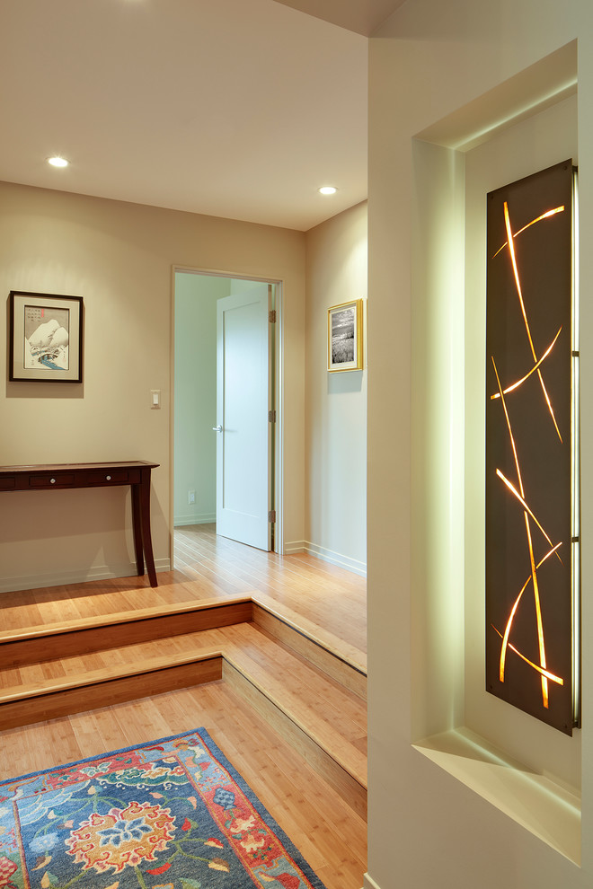 Idée de décoration pour un couloir design de taille moyenne avec un mur beige, parquet en bambou et un sol beige.