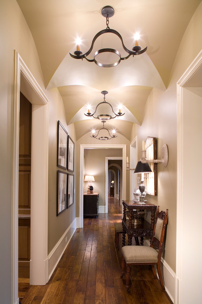 Cette image montre un couloir traditionnel de taille moyenne avec un mur beige et un sol en bois brun.
