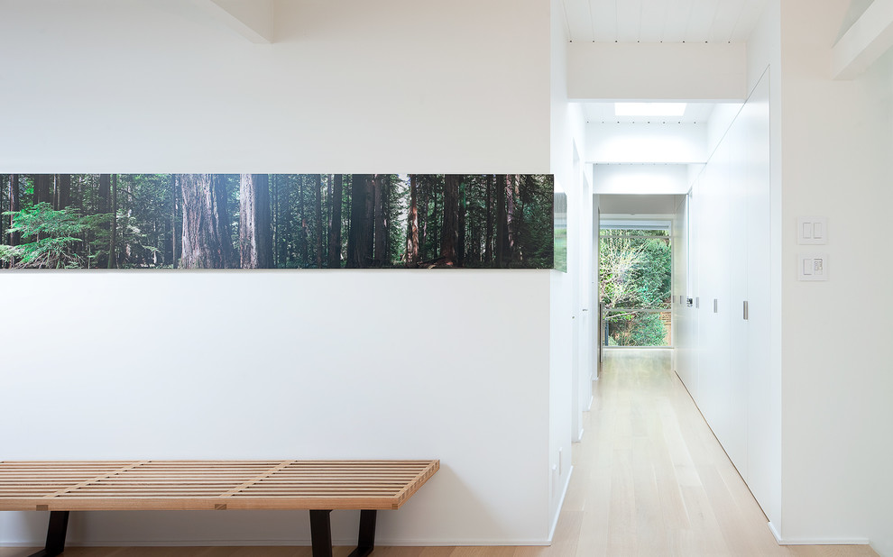 Moderner Flur mit weißer Wandfarbe und hellem Holzboden in Vancouver