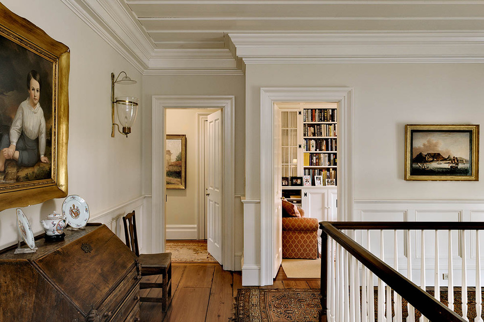 Inspiration for a timeless medium tone wood floor and brown floor hallway remodel in New York with white walls