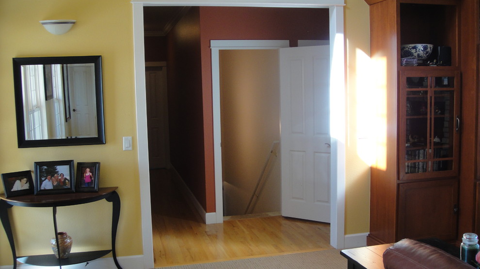 Idée de décoration pour un couloir craftsman de taille moyenne avec un mur orange et parquet clair.