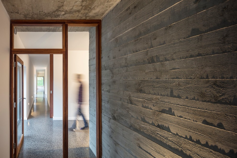 Idee per un grande ingresso o corridoio design con pareti grigie, pavimento in cemento e pavimento grigio