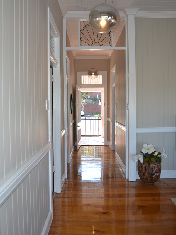Inspiration for a mid-sized timeless medium tone wood floor hallway remodel in Brisbane with beige walls