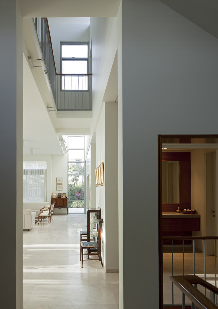 Свежая идея для дизайна: огромный коридор в стиле модернизм с белыми стенами и полом из известняка - отличное фото интерьера
