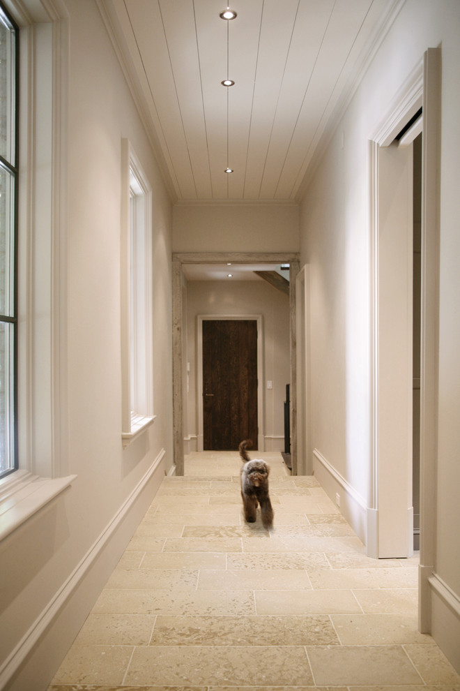 Idées déco pour un grand couloir classique avec un mur blanc et un sol en calcaire.