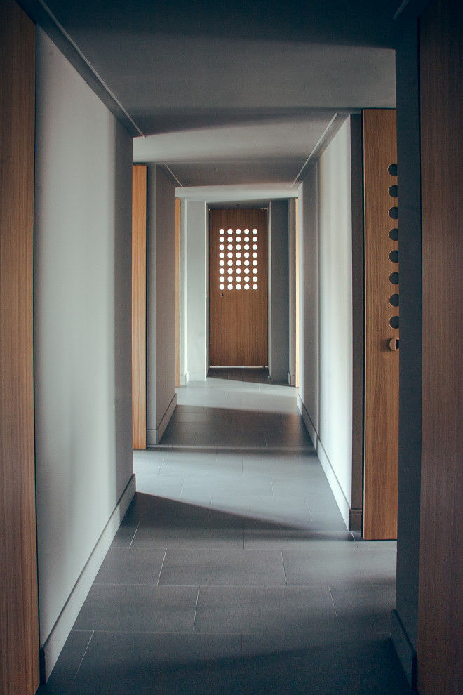 Inspiration pour un couloir design de taille moyenne avec un mur gris, un sol en calcaire et un sol gris.