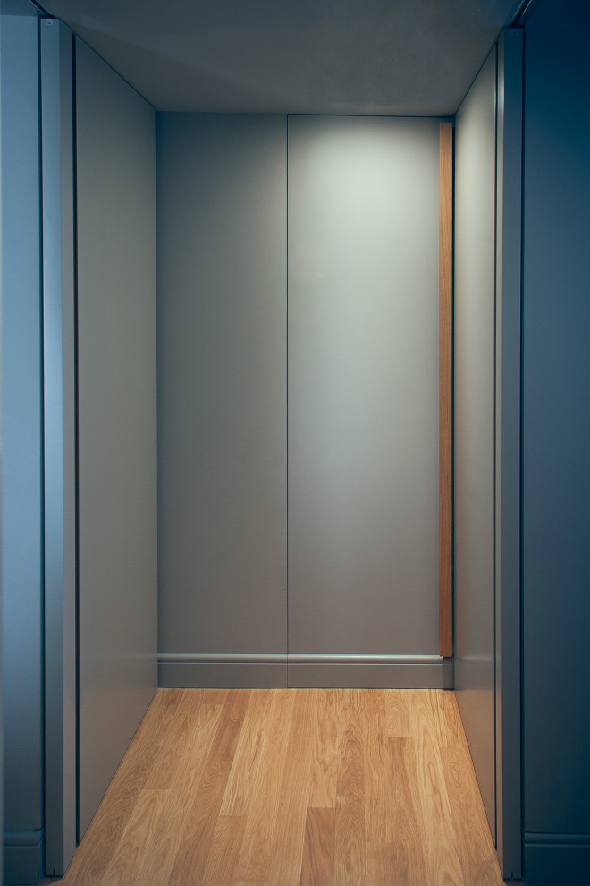Exemple d'un petit couloir moderne avec un mur gris et parquet clair.