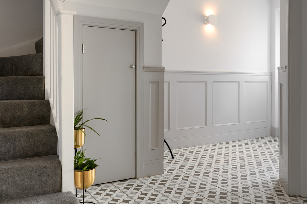 Aménagement d'un couloir classique avec un mur gris, un sol en carrelage de porcelaine et un sol multicolore.