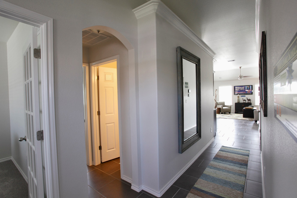 Inspiration pour un couloir traditionnel de taille moyenne avec un mur blanc, un sol en carrelage de céramique et un sol gris.