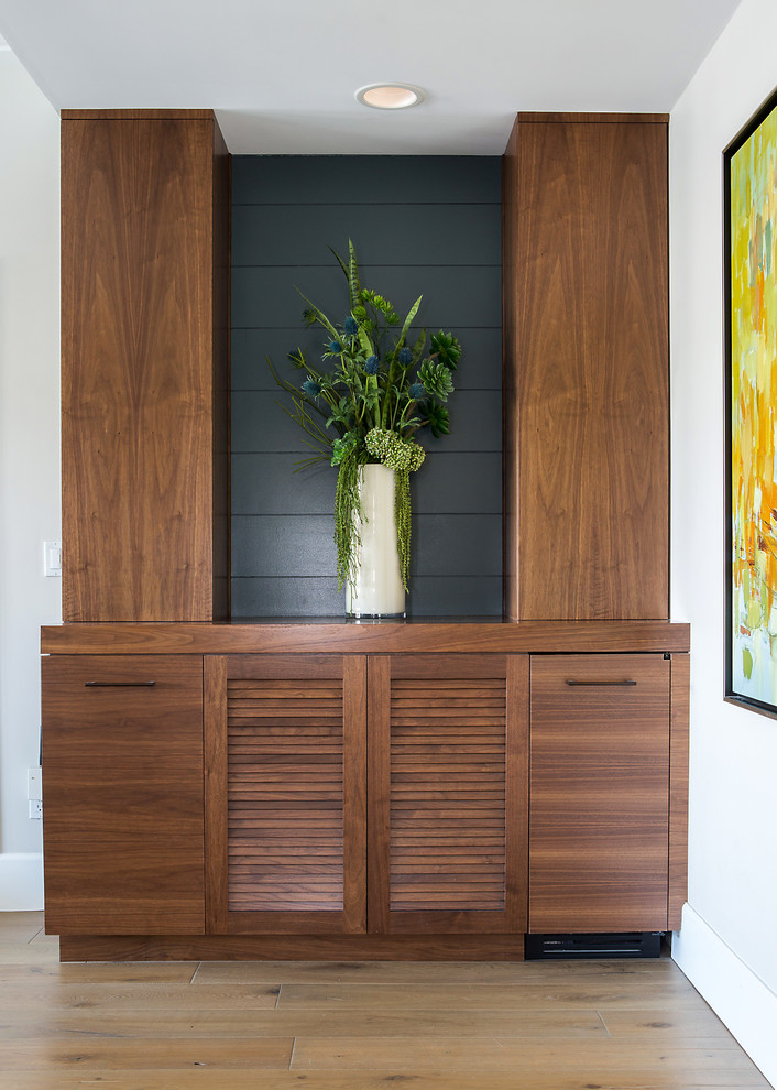 Hallway - contemporary medium tone wood floor and brown floor hallway idea in Orange County with white walls