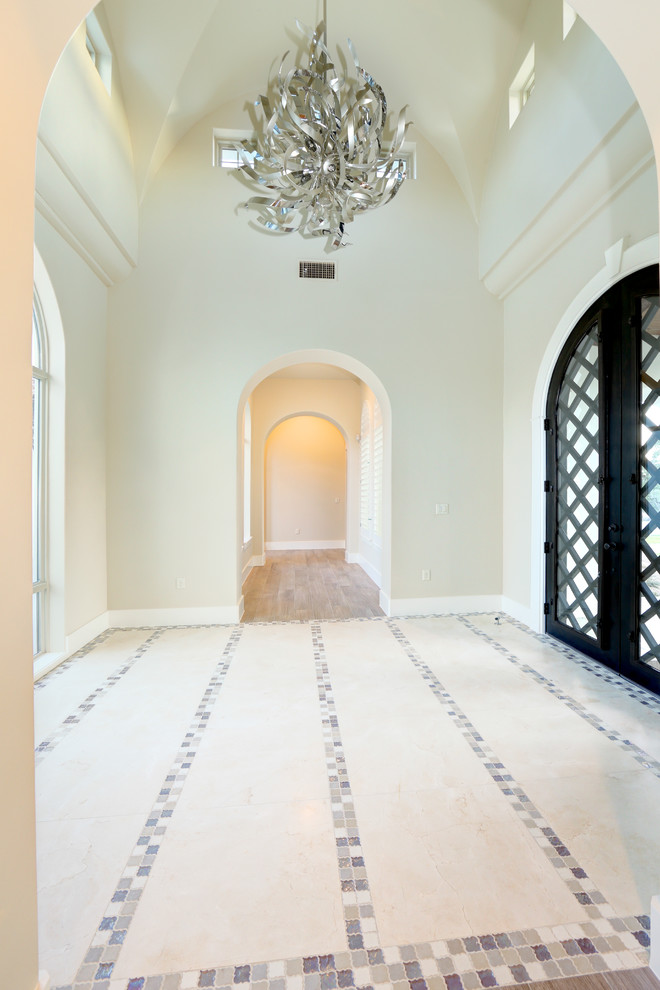 Стильный дизайн: большой коридор в стиле неоклассика (современная классика) с белыми стенами, полом из травертина и разноцветным полом - последний тренд