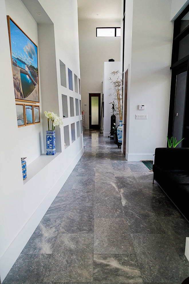 マイアミにある高級な広いトランジショナルスタイルのおしゃれな廊下 (大理石の床、白い壁) の写真
