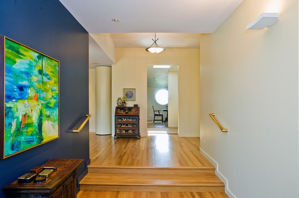 Inspiration pour un couloir vintage de taille moyenne avec un mur bleu, parquet clair et un sol marron.