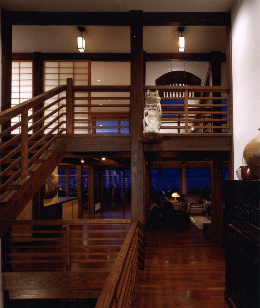 Exempel på en asiatisk hall, med vita väggar och mörkt trägolv
