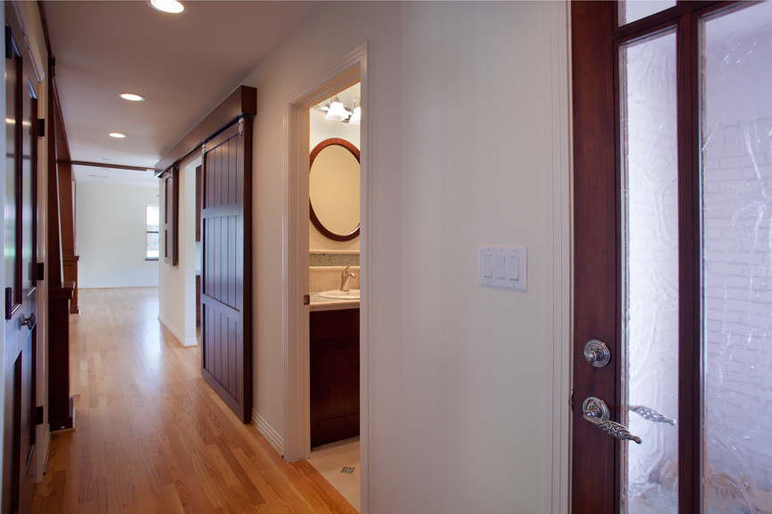 На фото: коридор среднего размера в стиле неоклассика (современная классика) с белыми стенами и светлым паркетным полом с