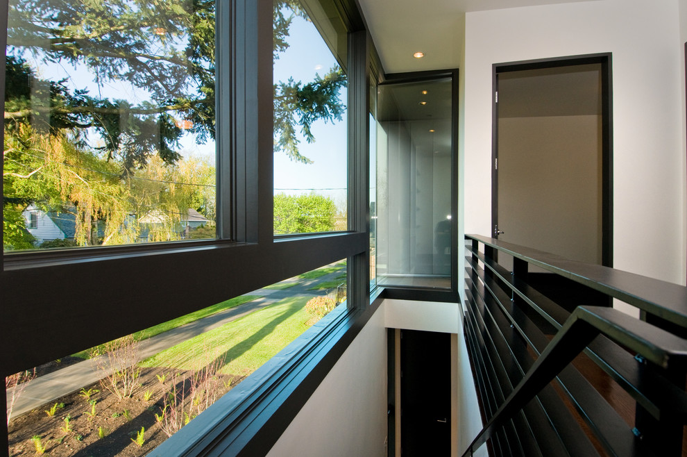 Modelo de recibidores y pasillos minimalistas de tamaño medio con paredes blancas, suelo de madera oscura y suelo marrón