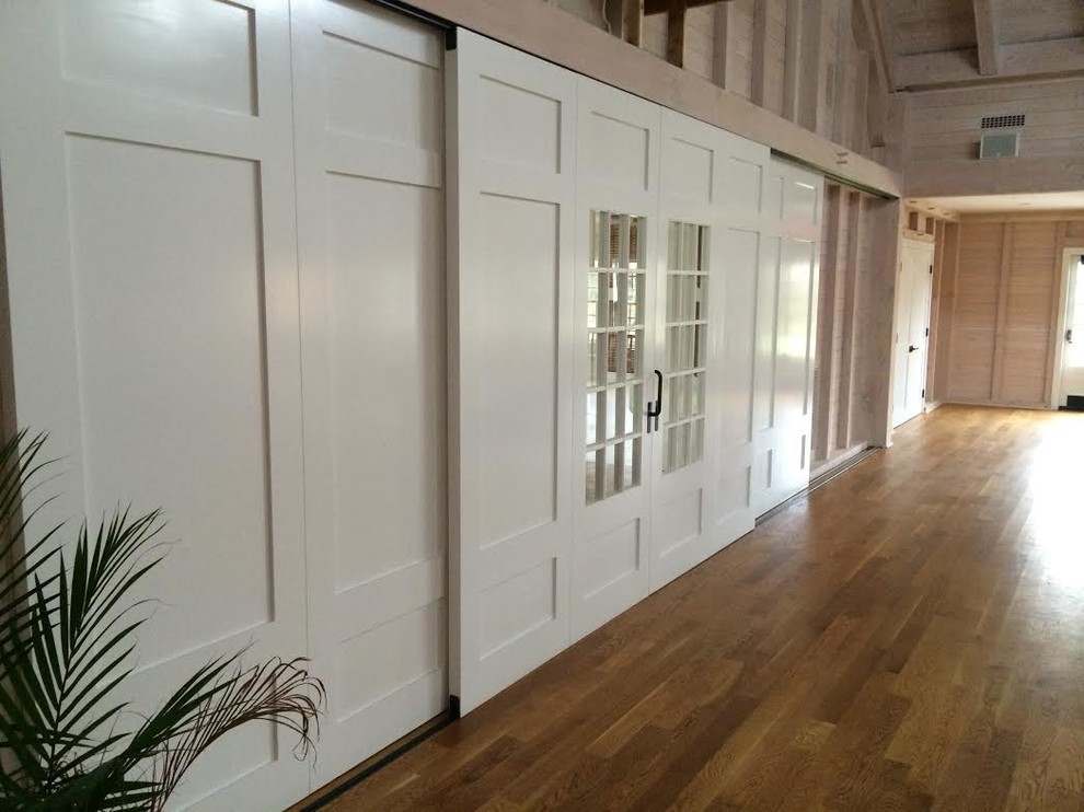 Ejemplo de recibidores y pasillos tradicionales renovados de tamaño medio con paredes blancas y suelo de madera en tonos medios
