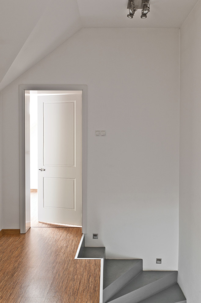Foto di un ingresso o corridoio minimal di medie dimensioni con pareti bianche, pavimento in legno massello medio e pavimento marrone