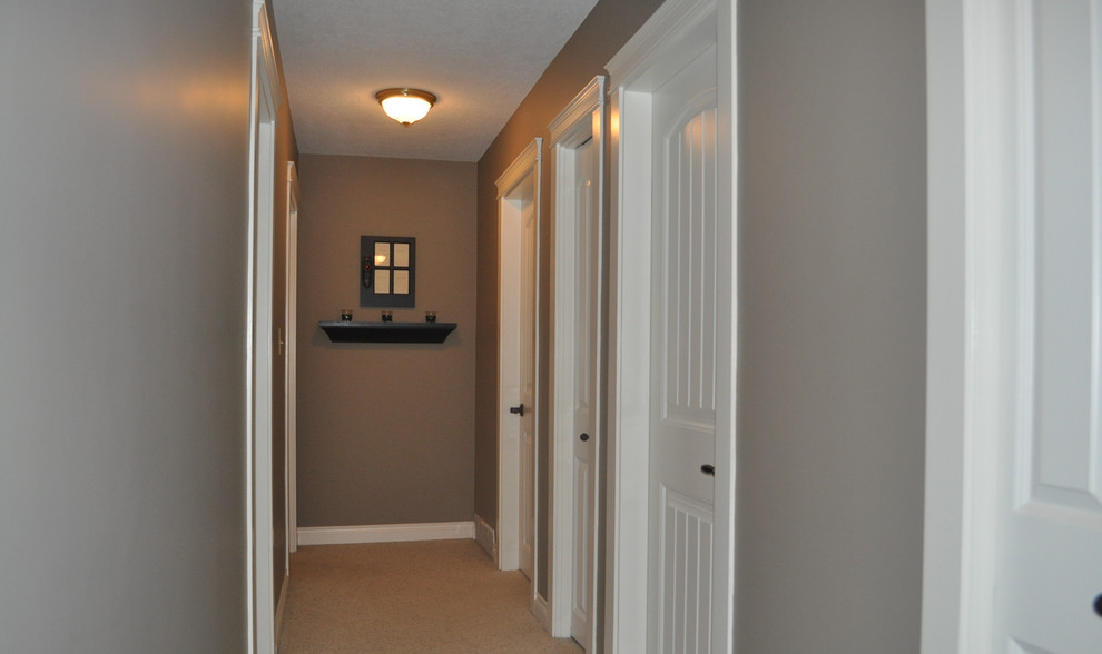 Immagine di un piccolo ingresso o corridoio chic con pareti marroni e moquette