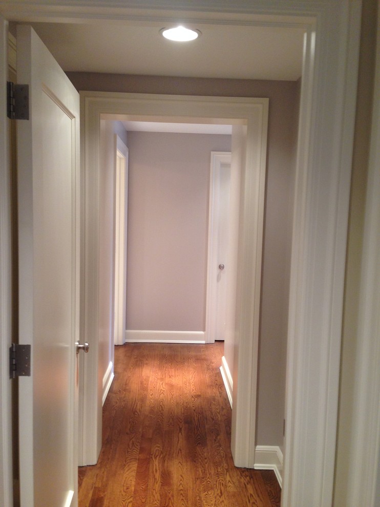 Mid-sized elegant dark wood floor hallway photo in Chicago with white walls