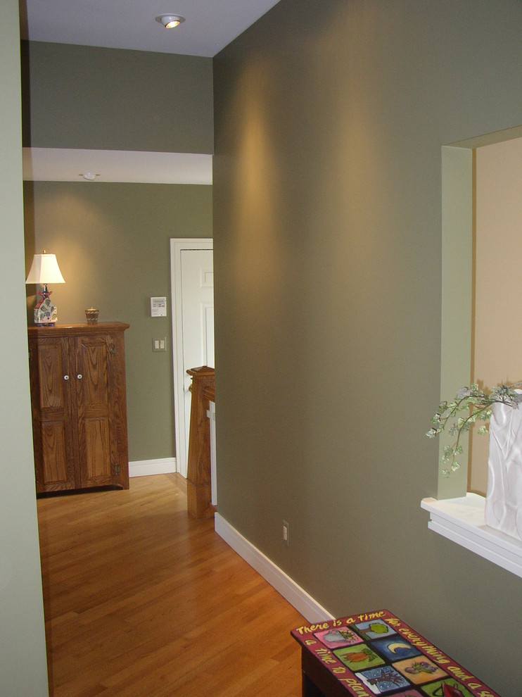 Inspiration for a mid-sized transitional medium tone wood floor and brown floor hallway remodel in Grand Rapids with green walls