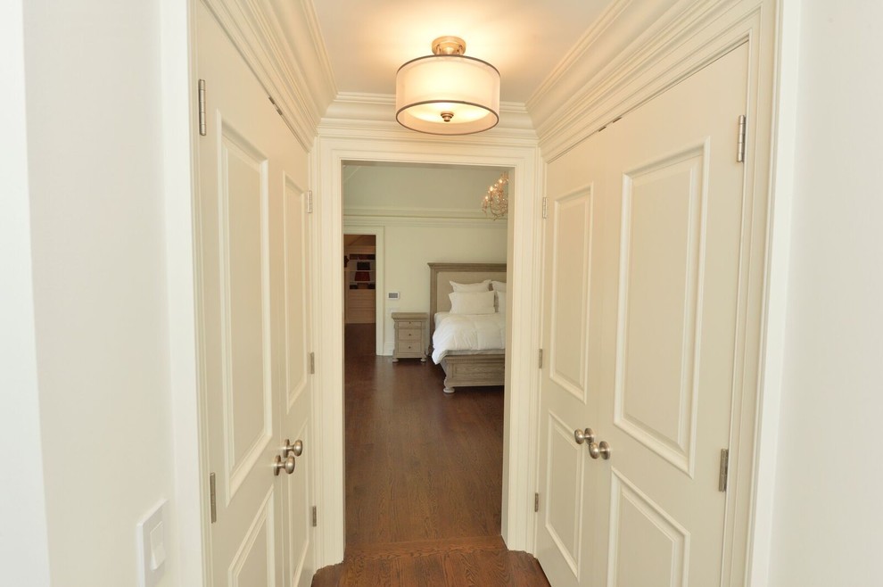 Esempio di un ingresso o corridoio classico di medie dimensioni con pareti bianche, pavimento in legno massello medio e pavimento beige