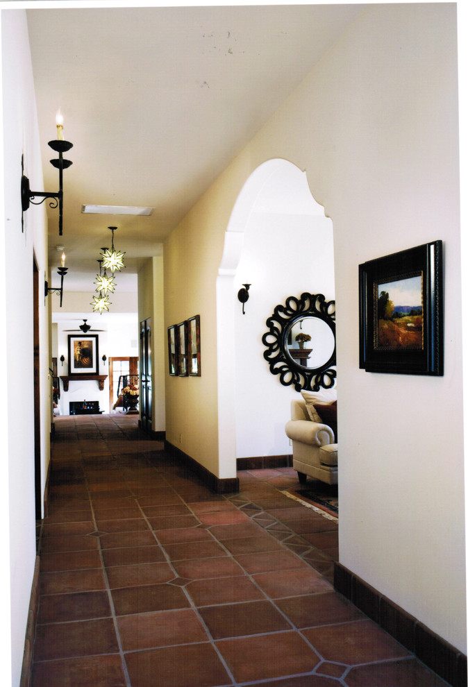 Inspiration for a large mediterranean terra-cotta tile hallway remodel in Santa Barbara with white walls